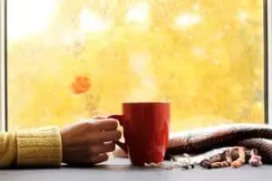 red mug of hot drink, when behind a window is rain in autumn in Salt Lake City