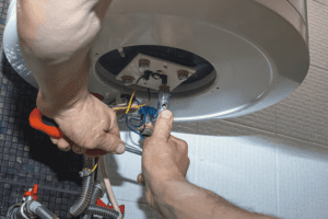 What Are Signs I Need a New Furnace? Image shows magnified view of HVAC professional replacing a furnace.