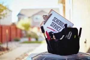 technician's bag sitting on an HVAC unit.