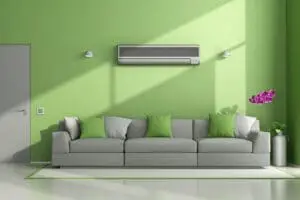 How Ductless System Can Help Your Home. Minimalist living room with air conditioner, sofa, and closed door.