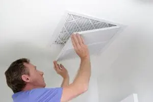 man opening vent to replace air filter.