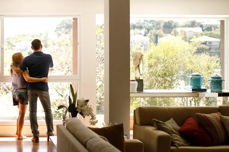 Couple standing in front of the window in summer.