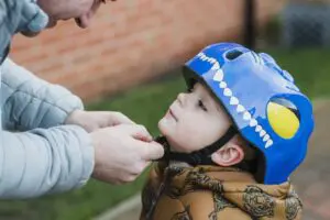 6 Ways Your Furnace Keeps You Safe. Photo of a father fastening young son's helmet.