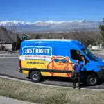 Just Right team member standing next to his van waving towards the customers home