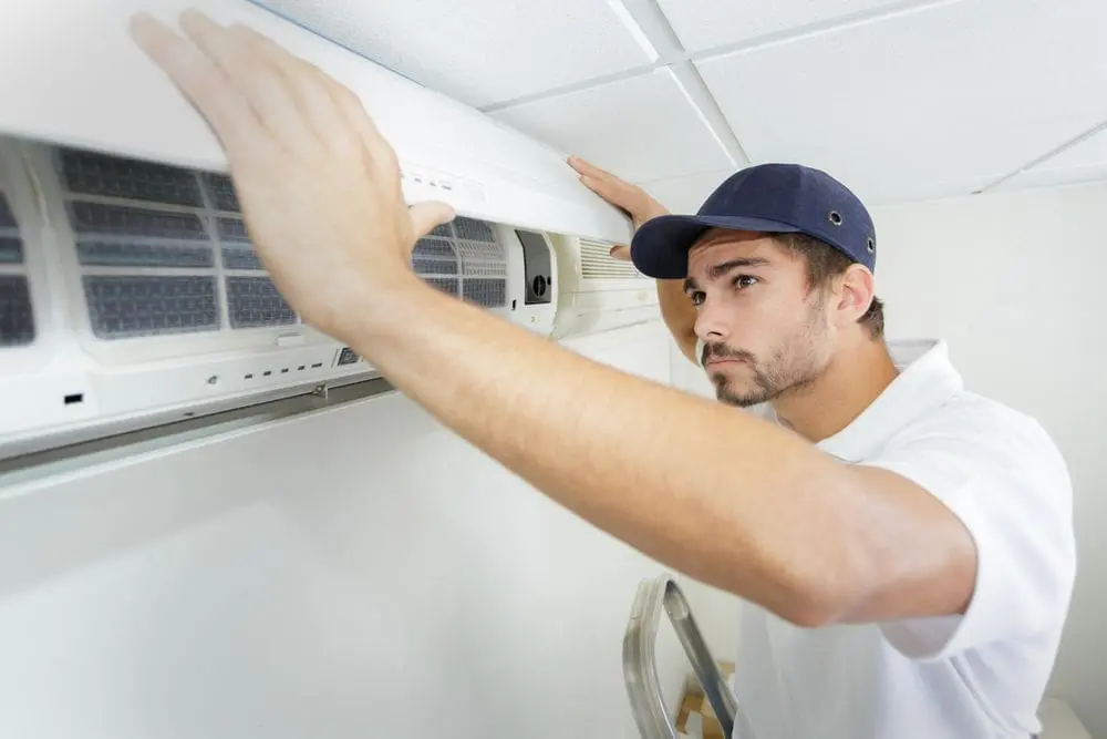 technician finishes installing residential ac unit