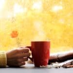 red mug of hot drink, when behind a window is rain in autumn in Salt Lake City