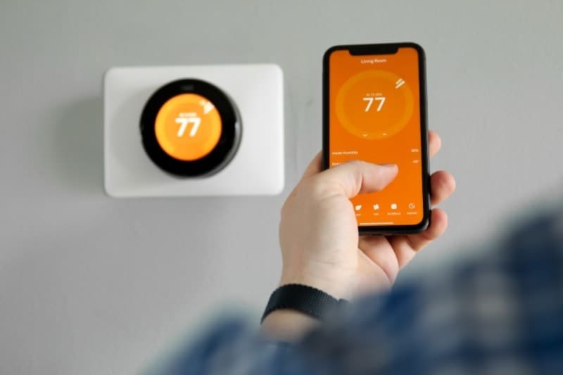 Air Conditioning Install - Just Right Homeowner using their smartphone on the smart thermostat