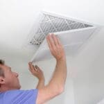 man opening vent to replace air filter.