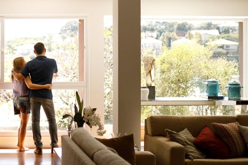 Couple standing in front of the window in summer.