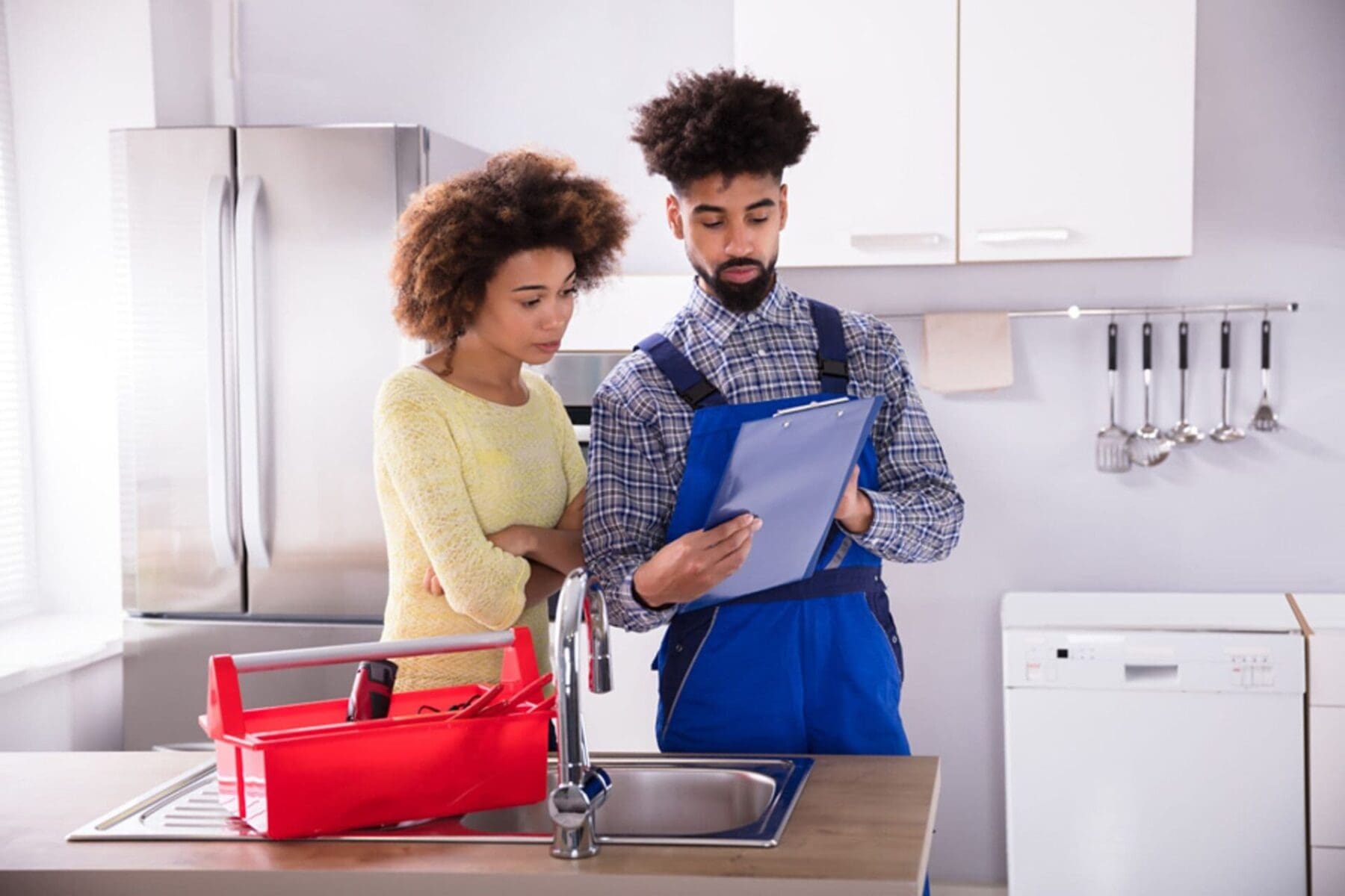 Hvac technician showing information on tablet to client in the kitchen of the client's home.