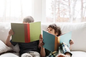 two brothers reading on a sofa