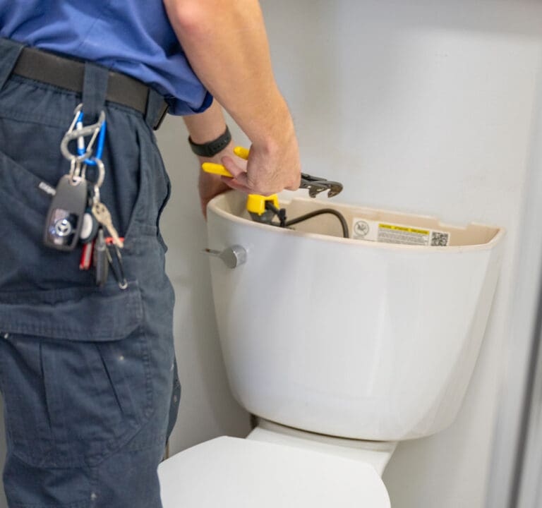 Toilet Repairs & Replacement - Just Right plumber fixing the back of a toilet