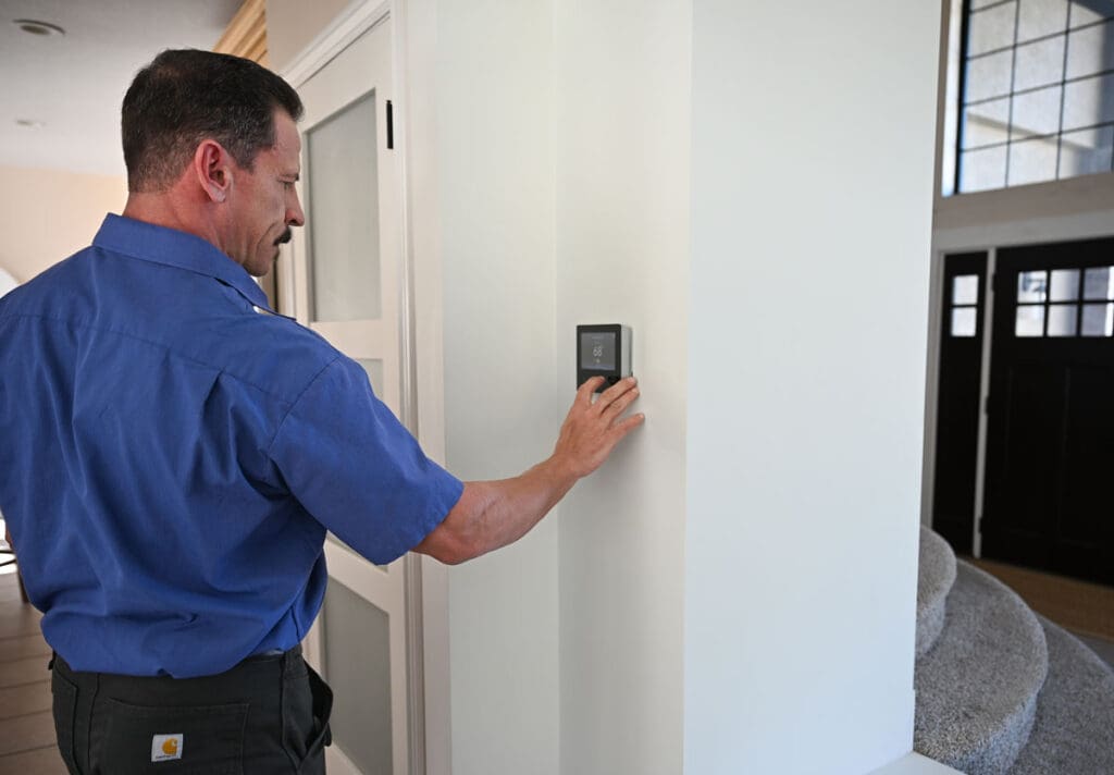 Ductless Mini Split Systems - Just Right just right team member adjusting the temperature on a thermostat