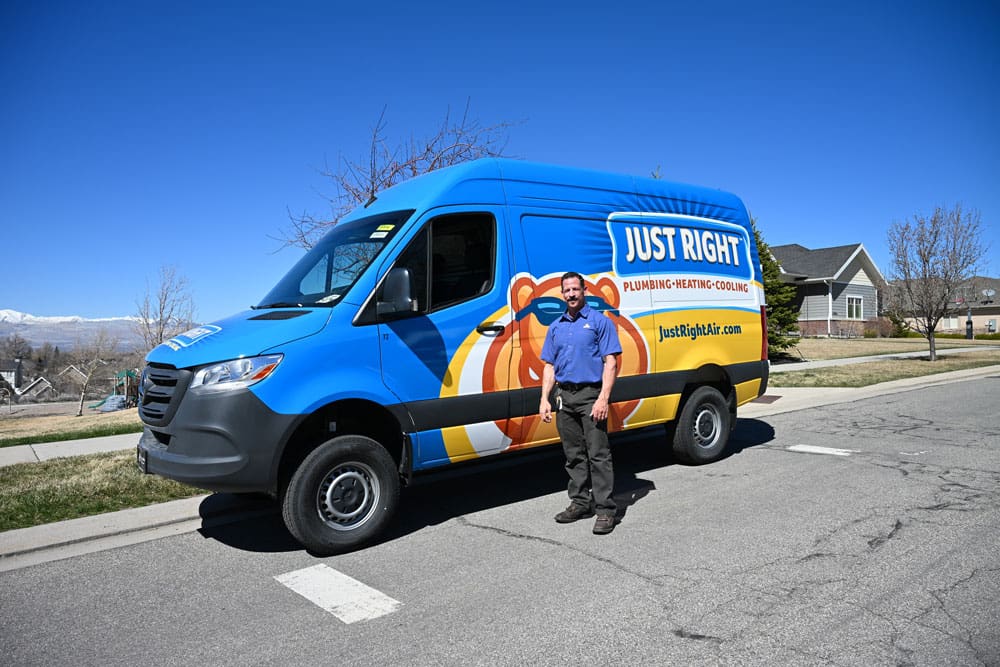 just right team member standing next to his service van