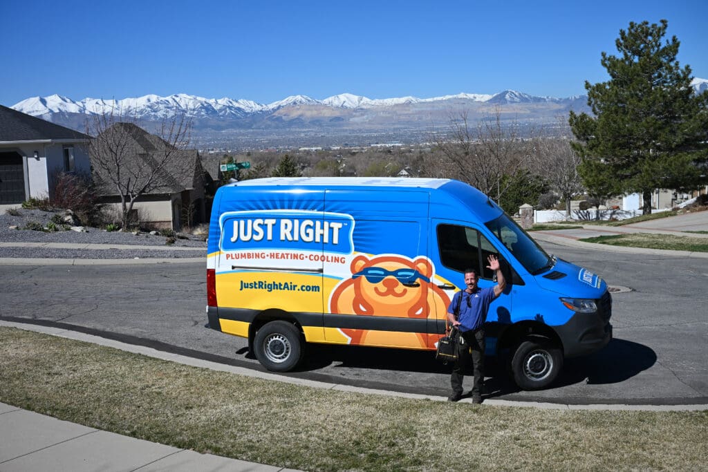 Salt Lake City Furnace Repairs - Just Right Just Right team member standing next to his van waving towards the customers home