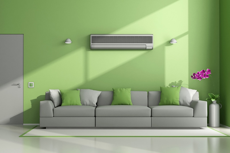 How Ductless System Can Help Your Home. Minimalist living room with air conditioner, sofa, and closed door.