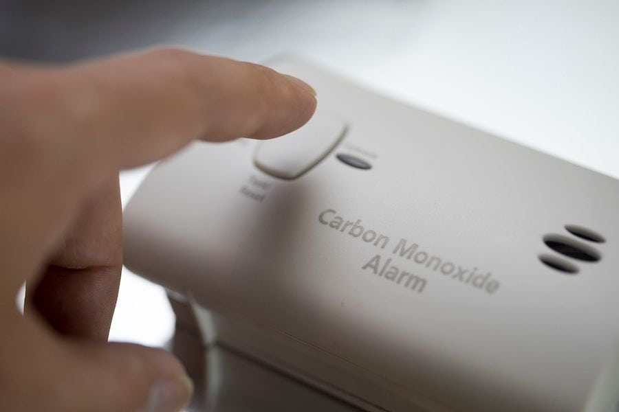 A person presses a carbon monoxide alarm. Learn the Facts About Carbon Monoxide.