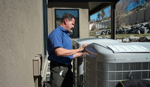 technician repairing air conditioning unit